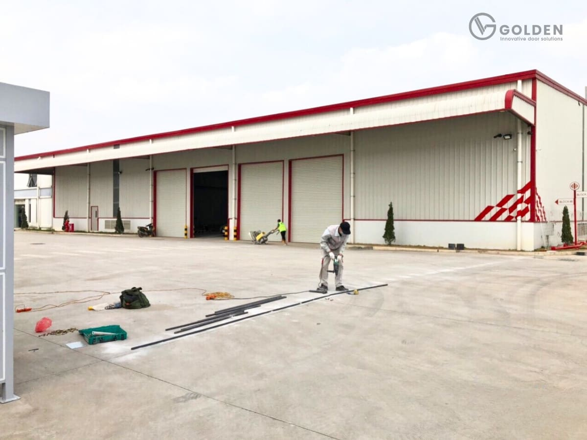 Kỹ thuật viên thi công cổng xếp trên nền bê tông có sẵn